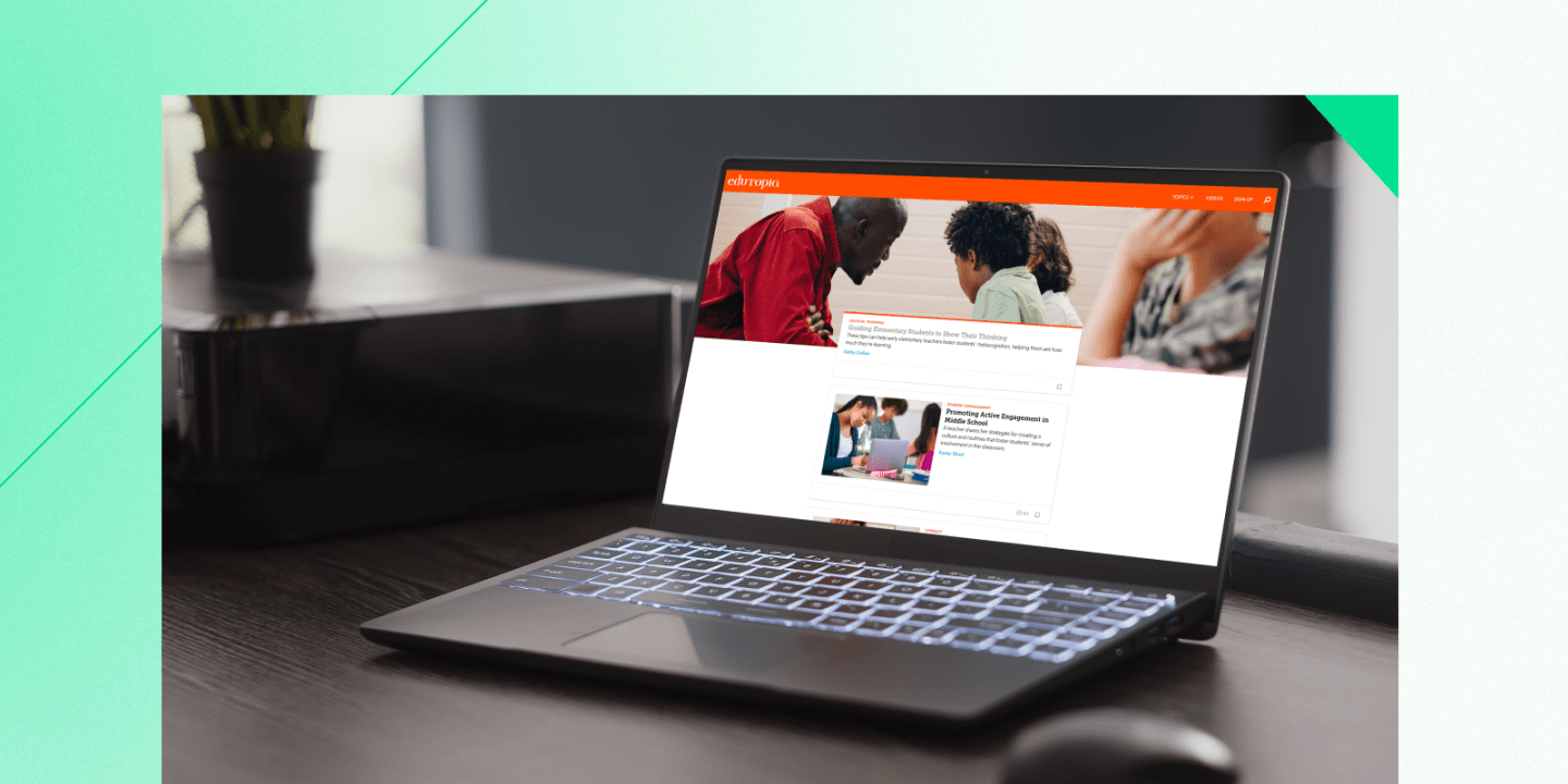 Laptop displaying the Edutopia website homepage, featuring education articles and images of students and teachers. The laptop is placed on a dark wooden desk beside a printer and plant, with backlit keys glowing softly.