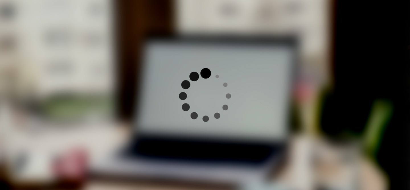 Blurred laptop screen with circular loading animation, representing fast page load improvements in WordPress.
