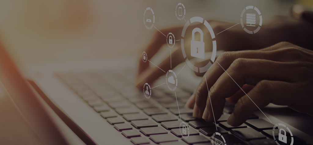 Close-up of hands typing on a laptop keyboard with semi-transparent icons overlaid, depicting cybersecurity symbols like padlocks and user profiles.
