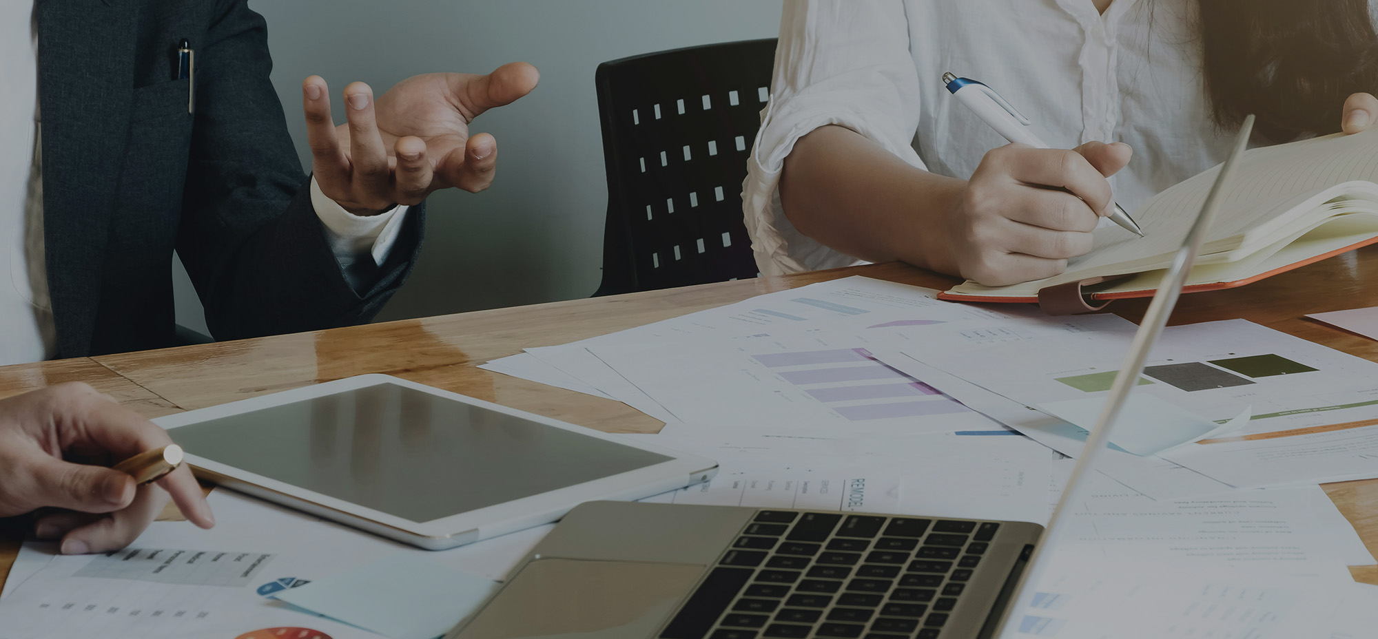 Enterprise stakeholders reviewing platform strategy documents and analytics reports across laptop, tablet, and printed materials, illustrating long-term architecture planning and collaborative decision-making.