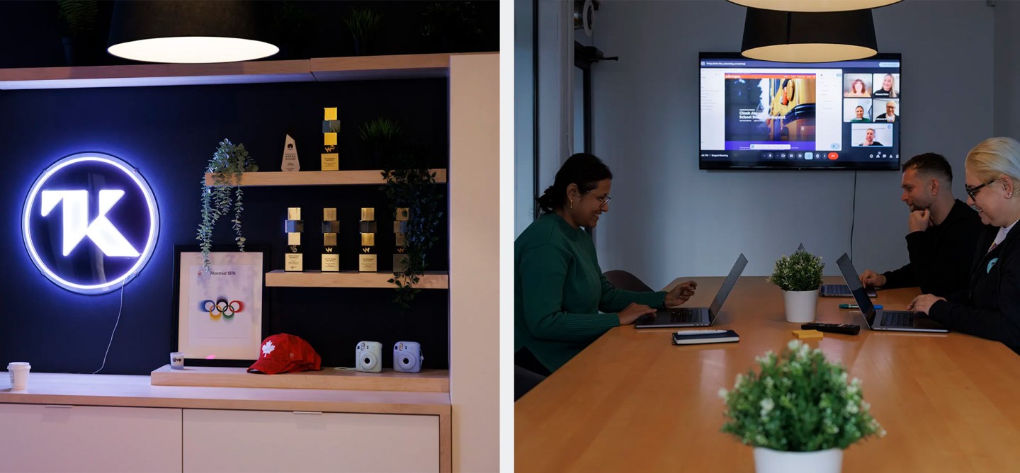 Office scene showing a shelf with awards and a neon TK logo on the left, and three colleagues working on laptops in a meeting room with a video call on a screen on the right.