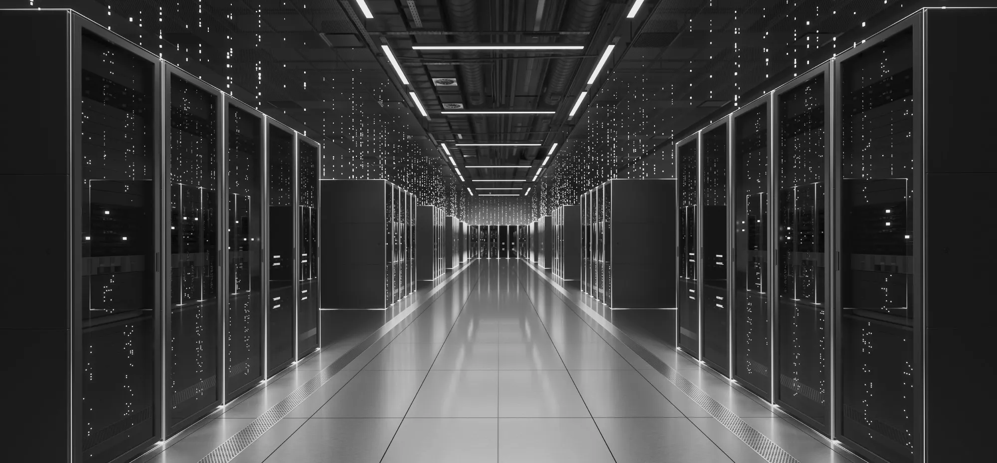 Black-and-white view of a modern data centre with rows of server racks lining a central aisle.